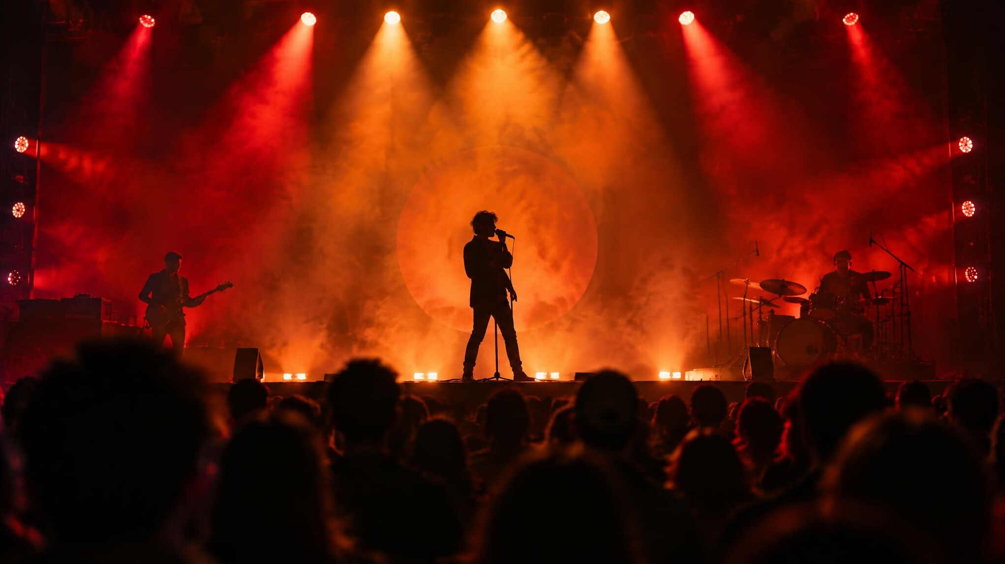 Wide shot of a live event stage lit with coloured spotlights during a performance