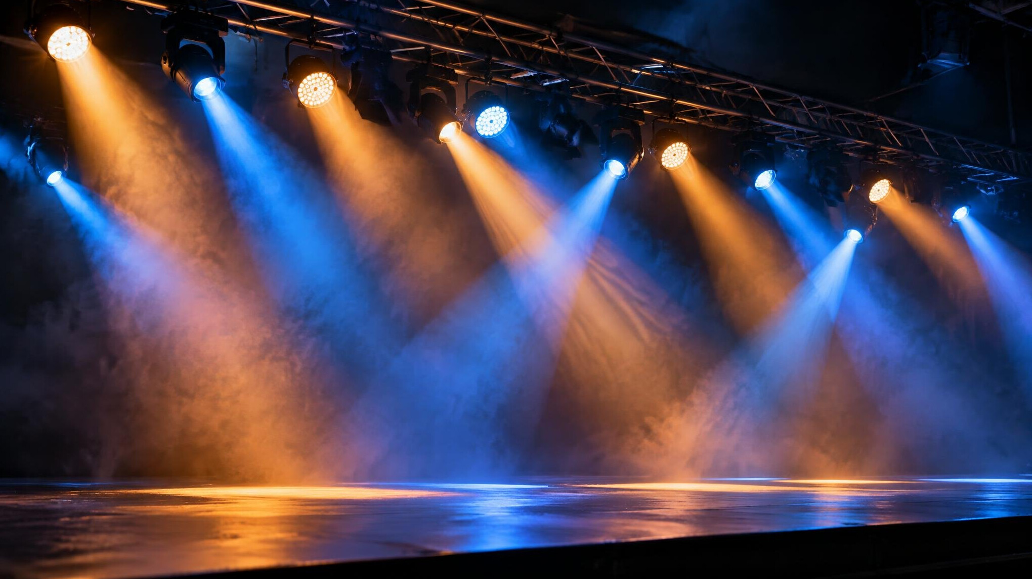 Row of stage spotlights aimed at an empty performance stage